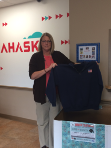 Administrative Assistant, Stacie Luckett displays one of the many jackets that was donated by an employee.
