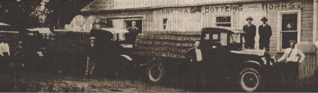 Vintage photo of a truck outside a bottling facility
