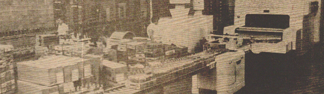 Vintage photo of a bottling facility with stacked boxes and machinery